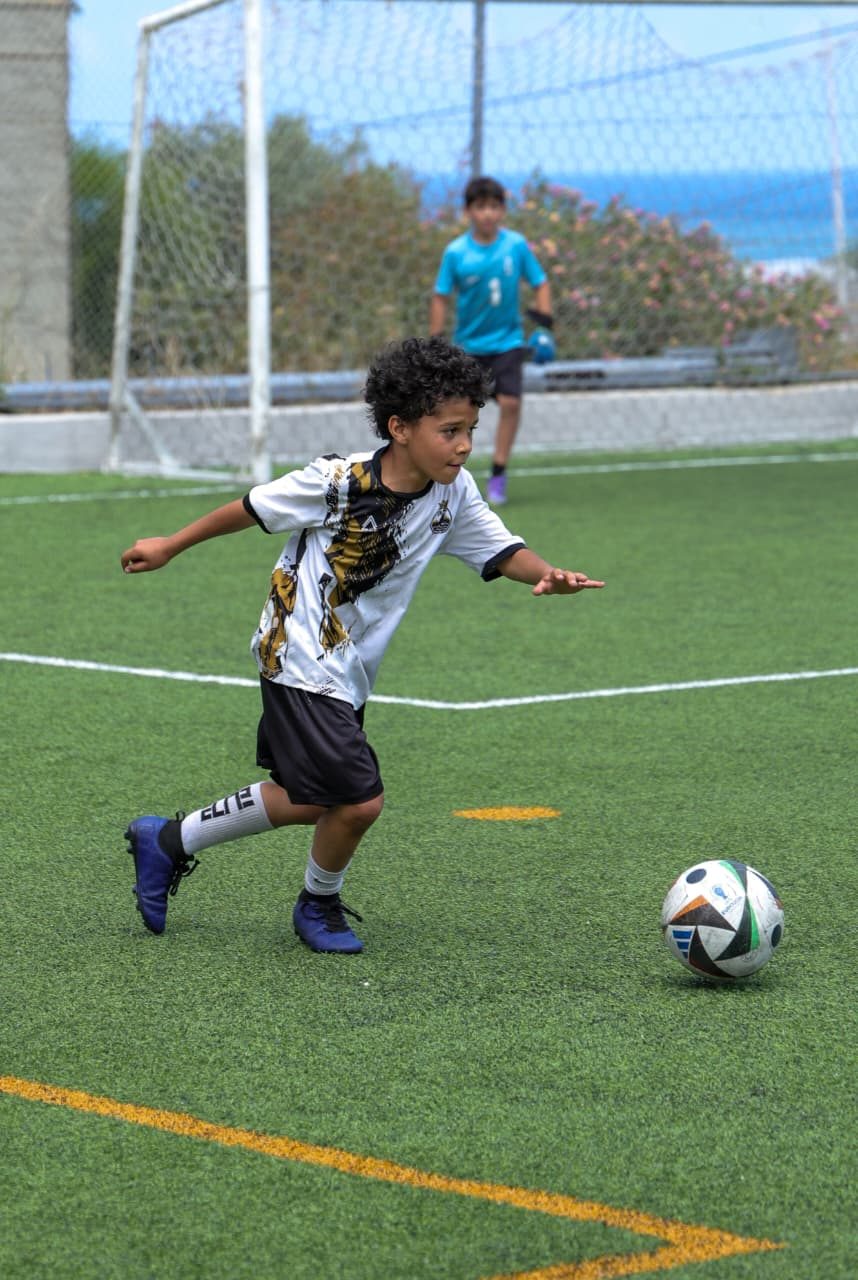 Player running with the ball, sea in the background