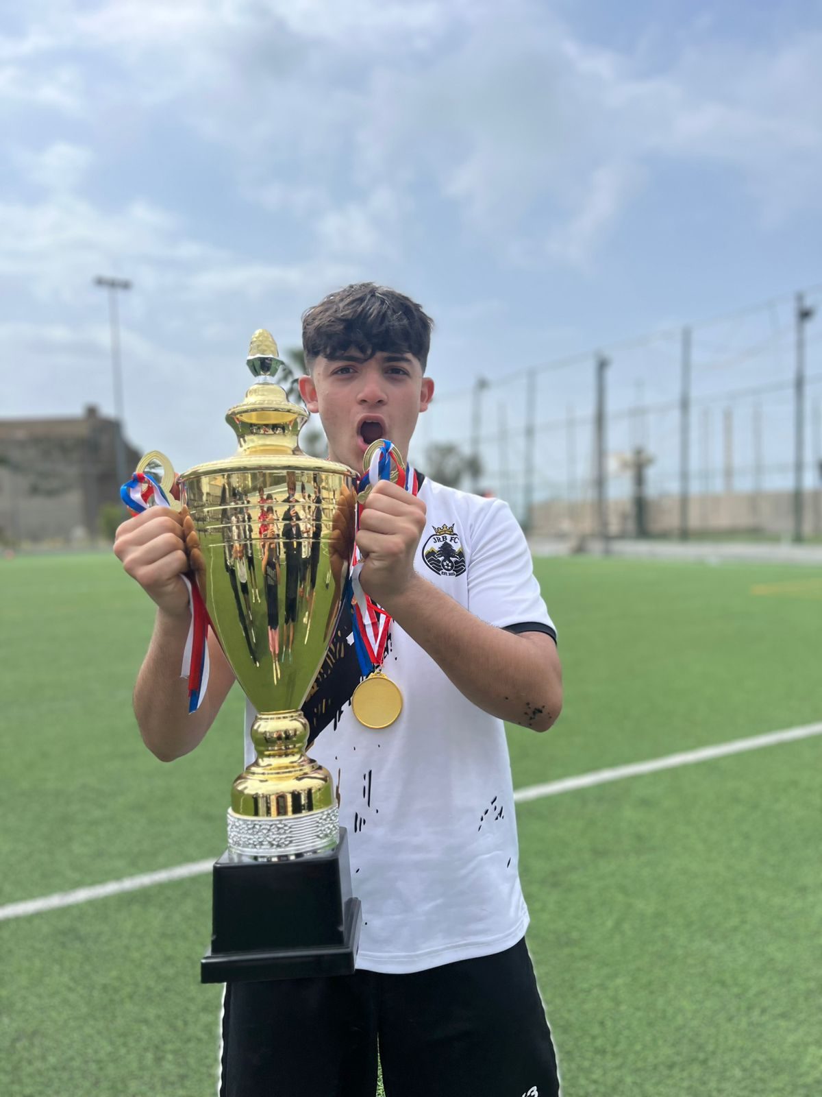 JRB FA player celebrating with a trophy
